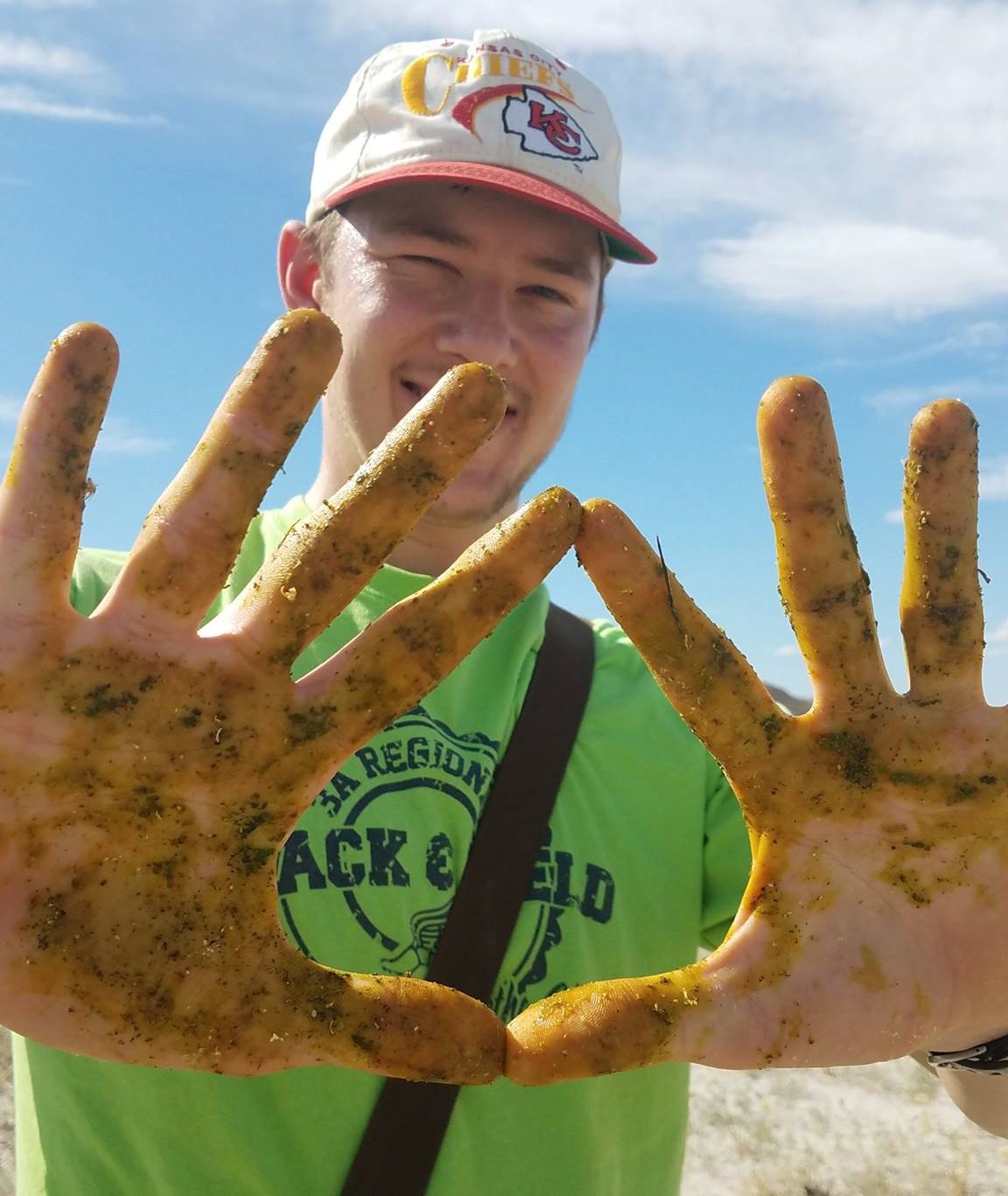 student showing off muddy hands